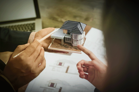A housing developer holding model and explaining concept to client