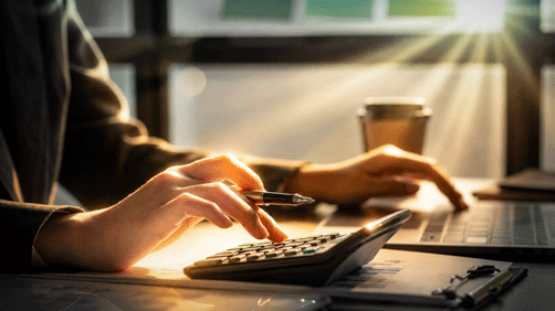 Business professional using a calculator to calculate numbers on a company's financial documents, he is analyzing historical financial data to plan how to grow the company. Financial concept.