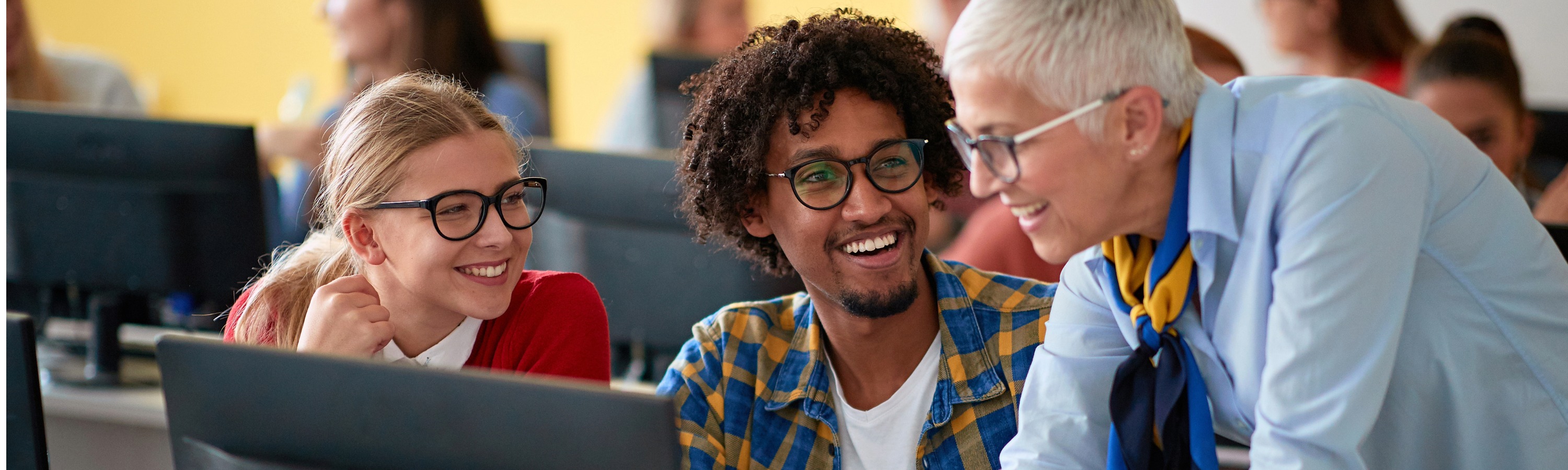 University professor working with happy valuation students in class