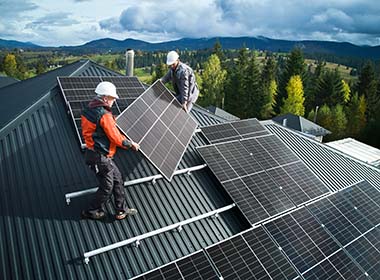 workers-building-solar-panel-system-on-roof-of-house-men-technicians-in-helmets-carrying-photovoltaic-solar-module-outdoors-concept-of-alternative-and-renewable-energy
