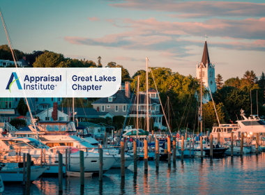This image features the harbor of Mackinac Island in Michigan, showcasing the iconic steeple of St. Anne's Church with the Appraisal Institute Great Lakes Chapter Logo