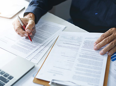 asian-businessman-reviewing-document-reports-at-office-workplace-with-computer-laptop-legal-expert-professional-lawyer-reading-and-checking-financial-documents-or-insurance-contract